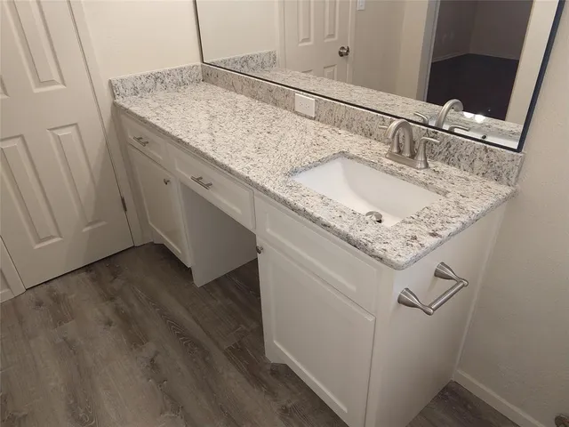 an empty room with wooden floor and chandelier fan