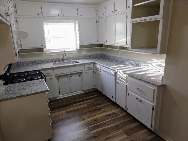 a kitchen with granite countertop cabinets stainless steel appliances a sink and a window