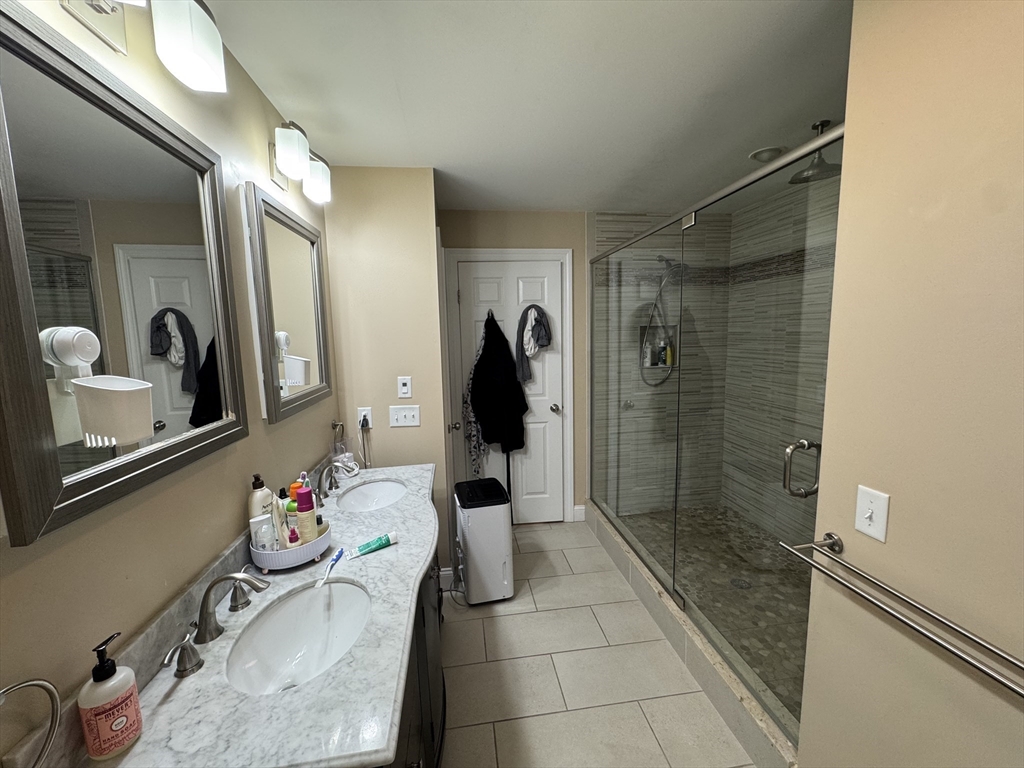 43 Canterbury Road Waltham, MA 02453 - Photo 27 of 42 a bathroom with a granite countertop shower a sink and a mirror