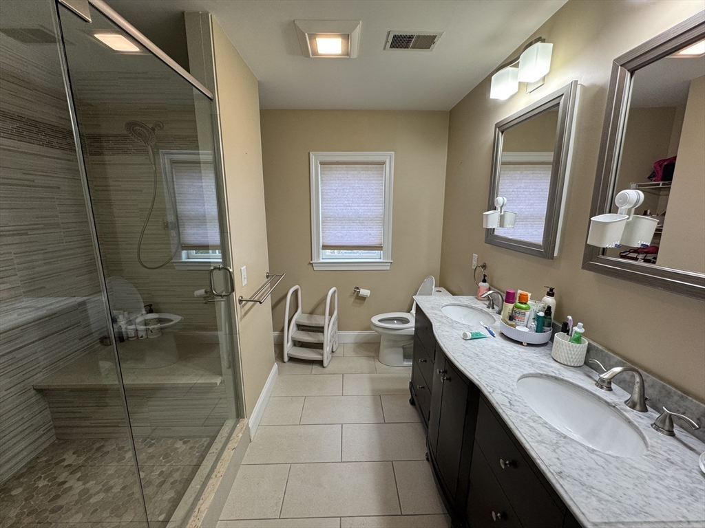 43 Canterbury Road Waltham, MA 02453 - Photo 28 of 42 a bathroom with a granite countertop sink a mirror and a bathtub