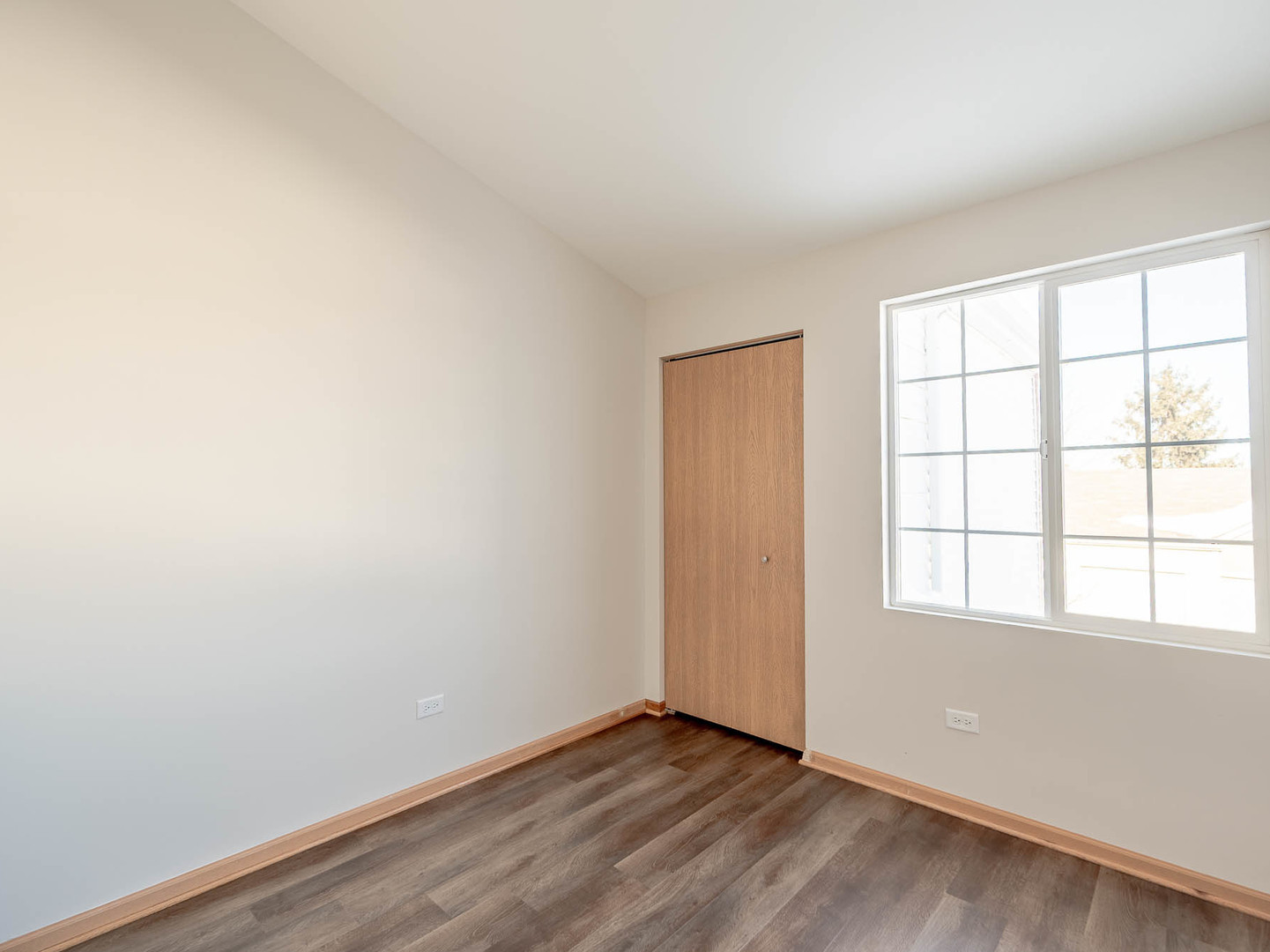 1648 McClure Road, Unit 1648 Aurora, IL 60505 - Photo 8 of 10 an empty room with wooden floor and windows