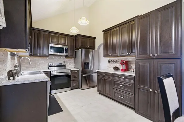 a kitchen with stainless steel appliances granite countertop a refrigerator stove and sink