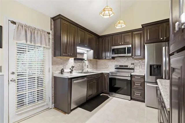 a kitchen with kitchen island granite countertop a stove sink microwave and refrigerator