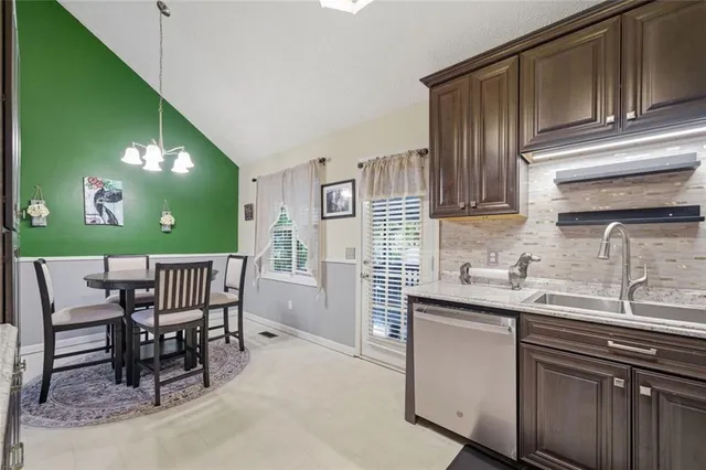 a kitchen with a sink cabinets and dining table chair