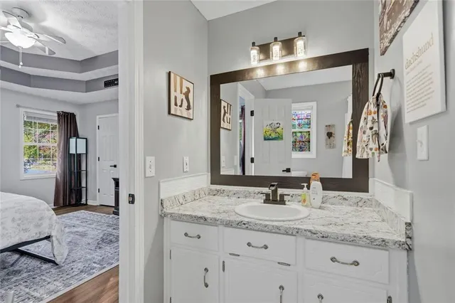 a bathroom with a granite countertop sink and a mirror