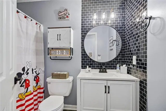 a bathroom with a sink mirror vanity and toilet
