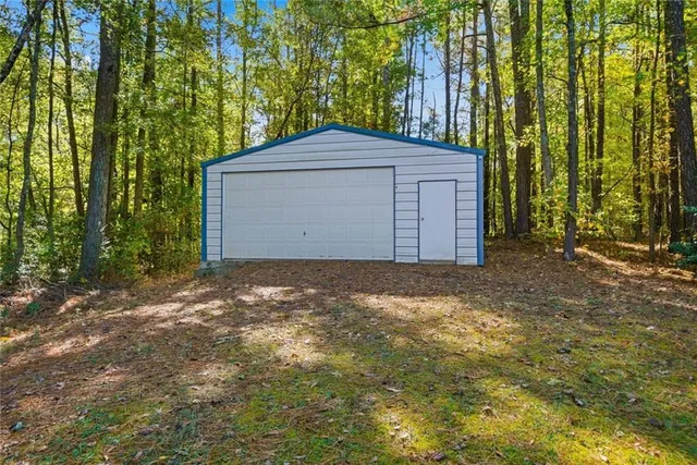 a backyard of a house with large trees and wooden fence