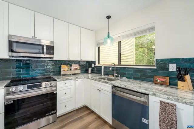 a kitchen with granite countertop cabinets stove top oven and microwave