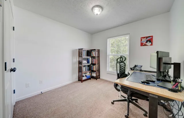 a view of a workspace with furniture and a bookshelf