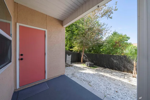 a view of backyard with potted plants and wooden fence