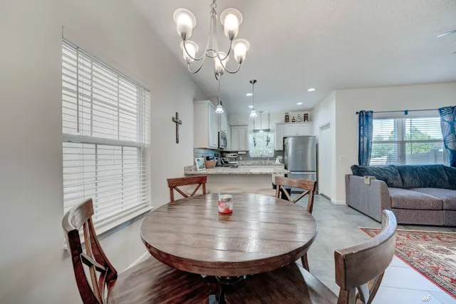 a dining room with furniture a rug and a chandelier
