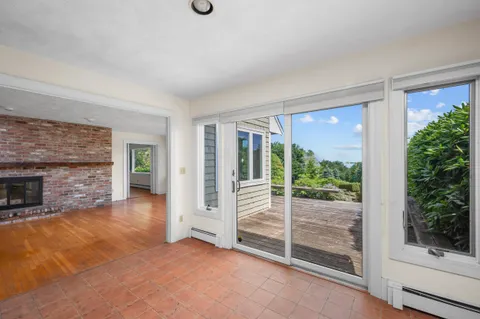 a view of a room with a large window and wooden floor