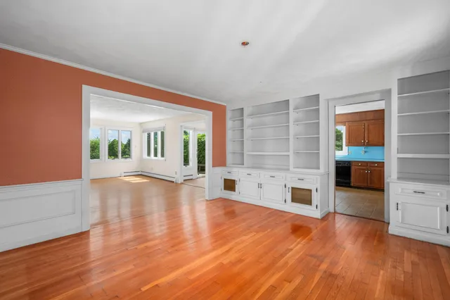 a view of empty room with wooden floor and fireplace