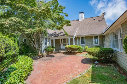 a view of a house with backyard sitting area and garden