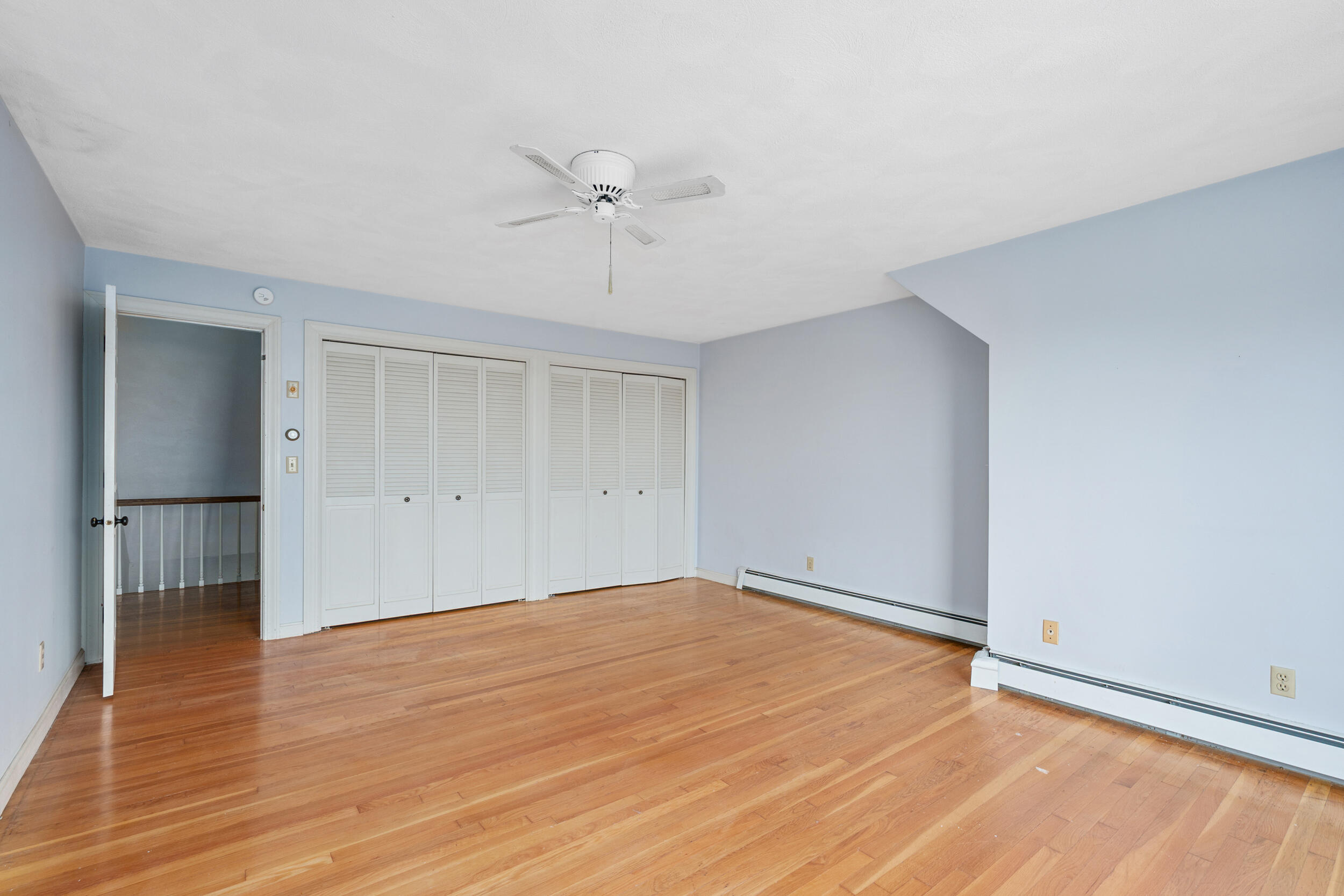 93 Harris Meadow Lane Barnstable, MA 02630 - Photo 34 of 64 a view of an empty room with wooden floor and a ceiling fan