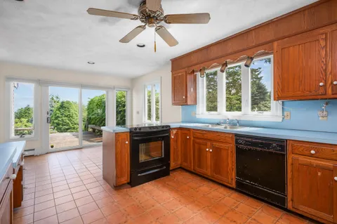 a kitchen with a sink window and cabinets