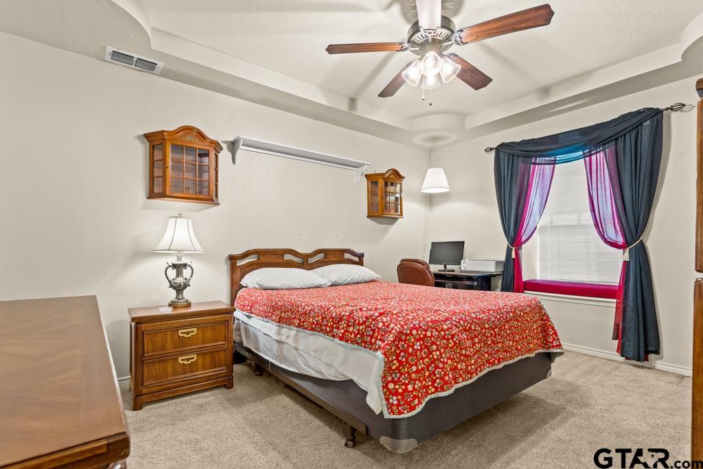 106 Cheyenne Street Gilmer, TX 75644 - Photo 12 of 48 a bedroom with a bed and dresser with mirror