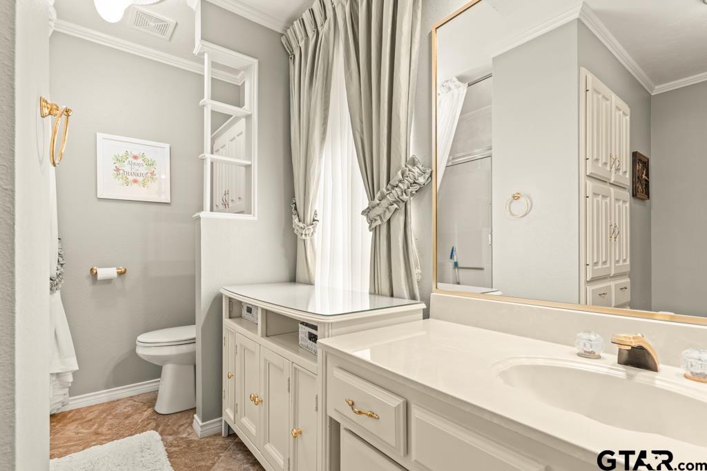 106 Cheyenne Street Gilmer, TX 75644 - Photo 14 of 48 a bathroom with a sink a toilet and a mirror