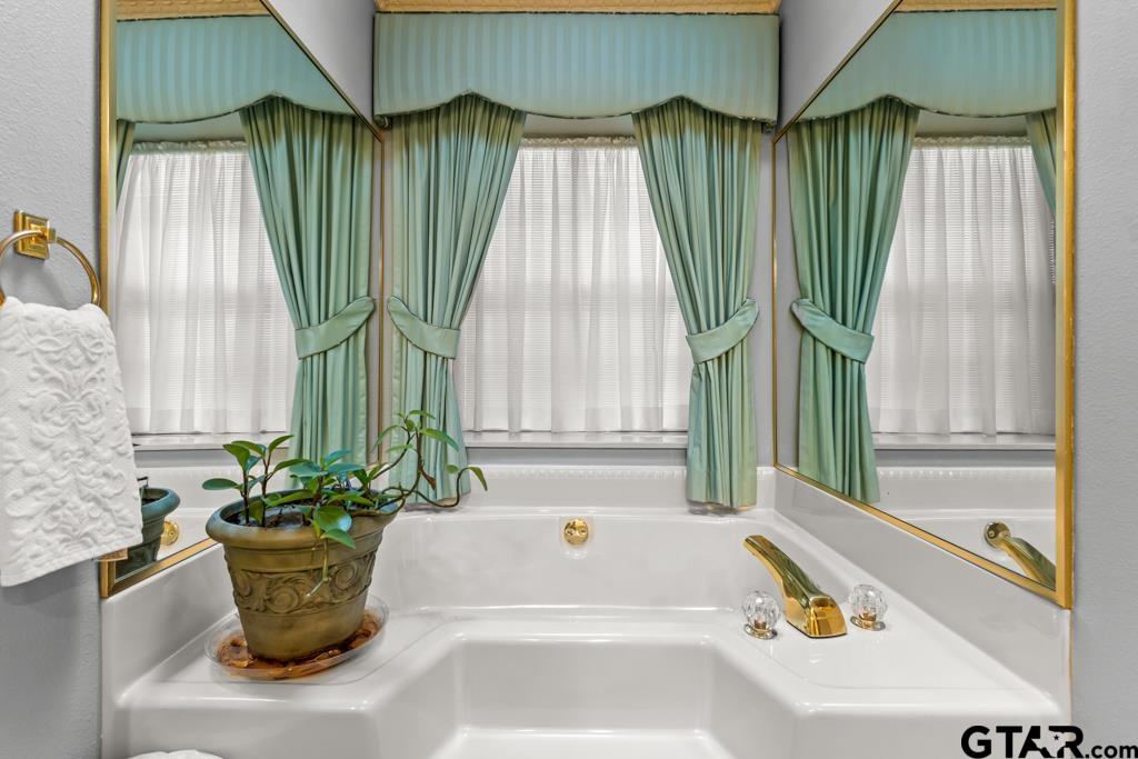 106 Cheyenne Street Gilmer, TX 75644 - Photo 21 of 48 a bathroom with a bathtub and window