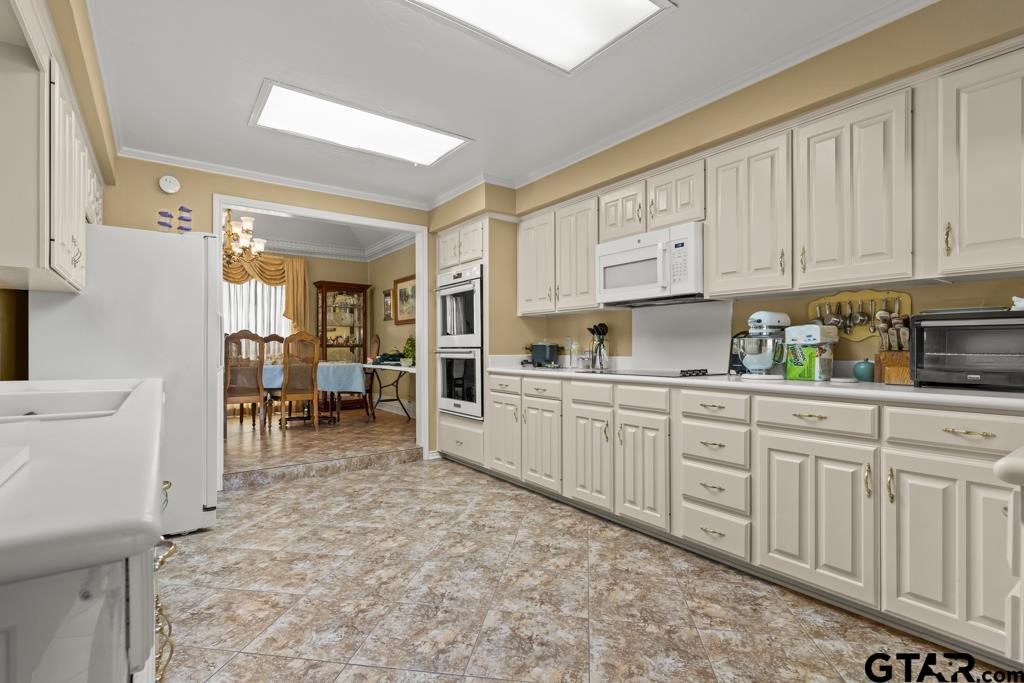 106 Cheyenne Street Gilmer, TX 75644 - Photo 7 of 48 a kitchen with cabinets and chairs