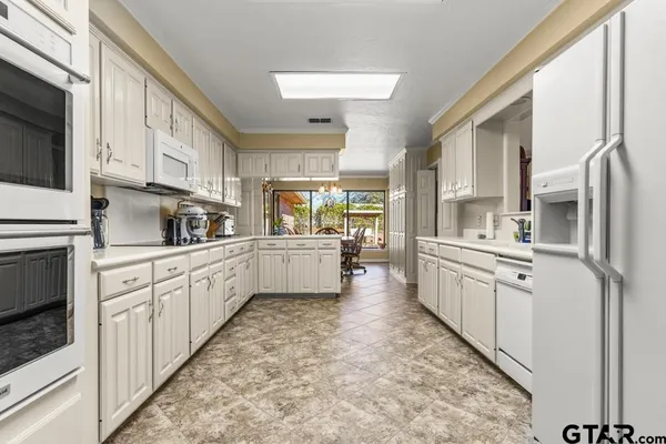 a kitchen with white cabinets and white appliances