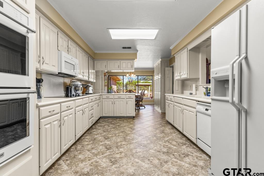 106 Cheyenne Street Gilmer, TX 75644 - Photo 8 of 48 a kitchen with white cabinets and white appliances