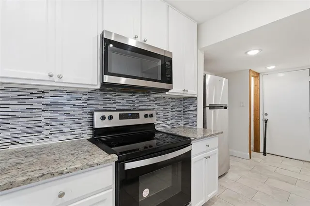 a kitchen with stainless steel appliances granite countertop a stove microwave and refrigerator