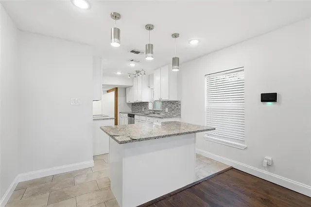 a kitchen with a sink cabinetry and chandelier