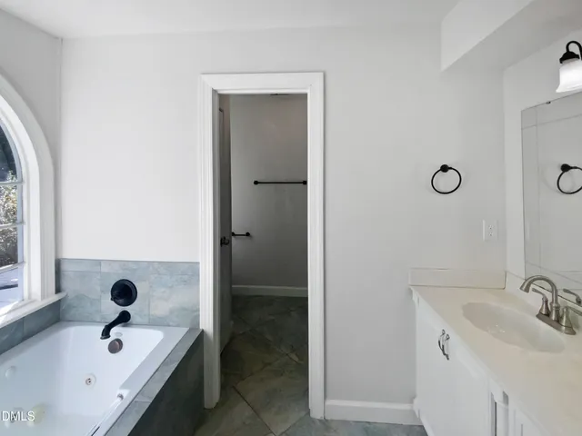 a bathroom with a tub sink and mirror