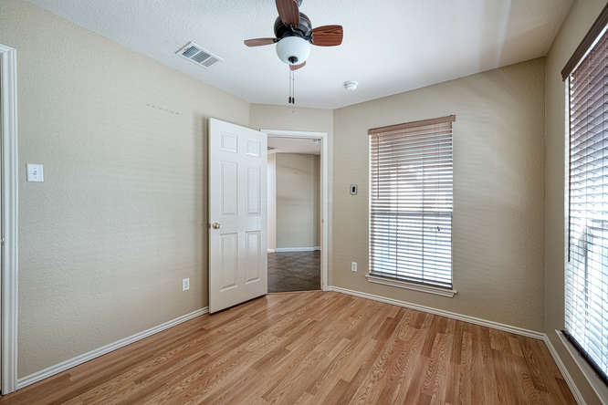 205 Polk Kyle, TX 78640 - Photo 12 of 22 Room featuring wood-finish flooring, neutral wall paint, and a ceiling fan with light fixture