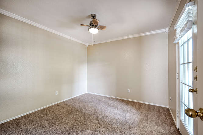 205 Polk Kyle, TX 78640 - Photo 16 of 22 Carpeted room featuring a ceiling fan with light fixture, crown molding, baseboards, and a glass-paneled door