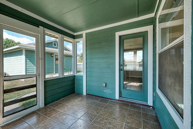 205 Polk Kyle, TX 78640 - Photo 19 of 22 Screened porch featuring a tiled floor, white trim, and a full-light glass door