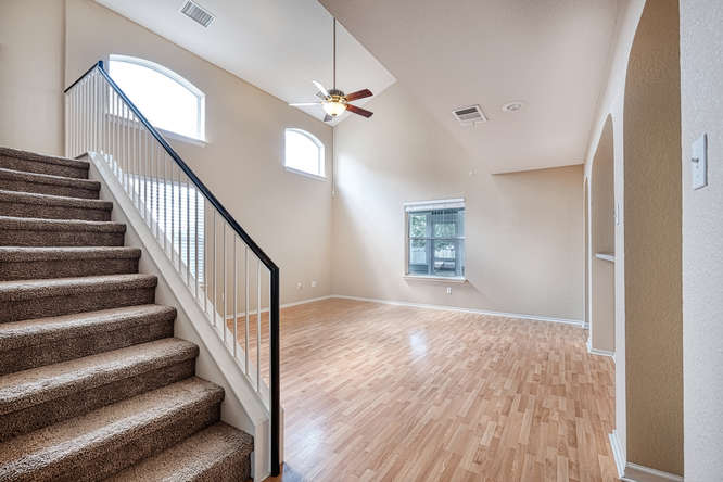 205 Polk Kyle, TX 78640 - Photo 3 of 22 Carpeted staircase with white balusters and a dark handrail