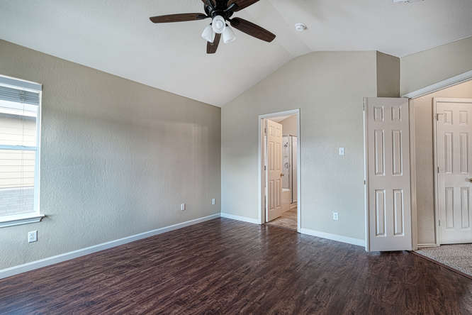 205 Polk Kyle, TX 78640 - Photo 8 of 22 Vaulted ceiling room featuring wood-finish flooring, a ceiling fan, and window with blinds