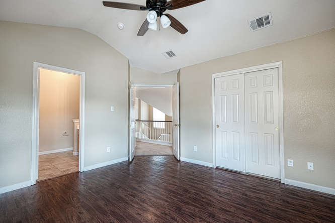 205 Polk Kyle, TX 78640 - Photo 9 of 22 Spacious room featuring rich wood-finish flooring, neutral wall tones, and a ceiling fan with integrated lighting