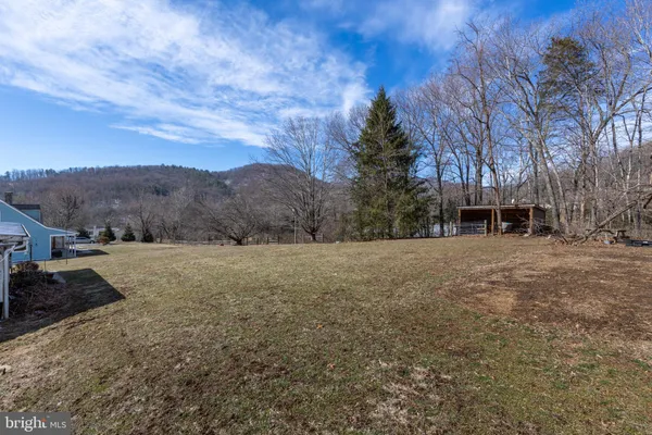 a view of a house with backyard and trees