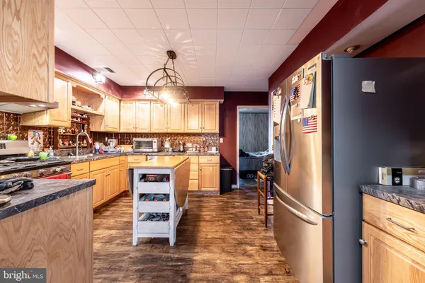 a kitchen with stainless steel appliances granite countertop a sink a stove and a refrigerator