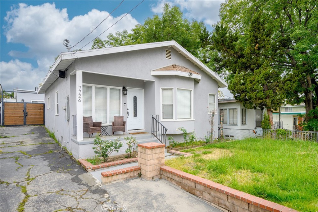 a front view of house with yard and trees in the background