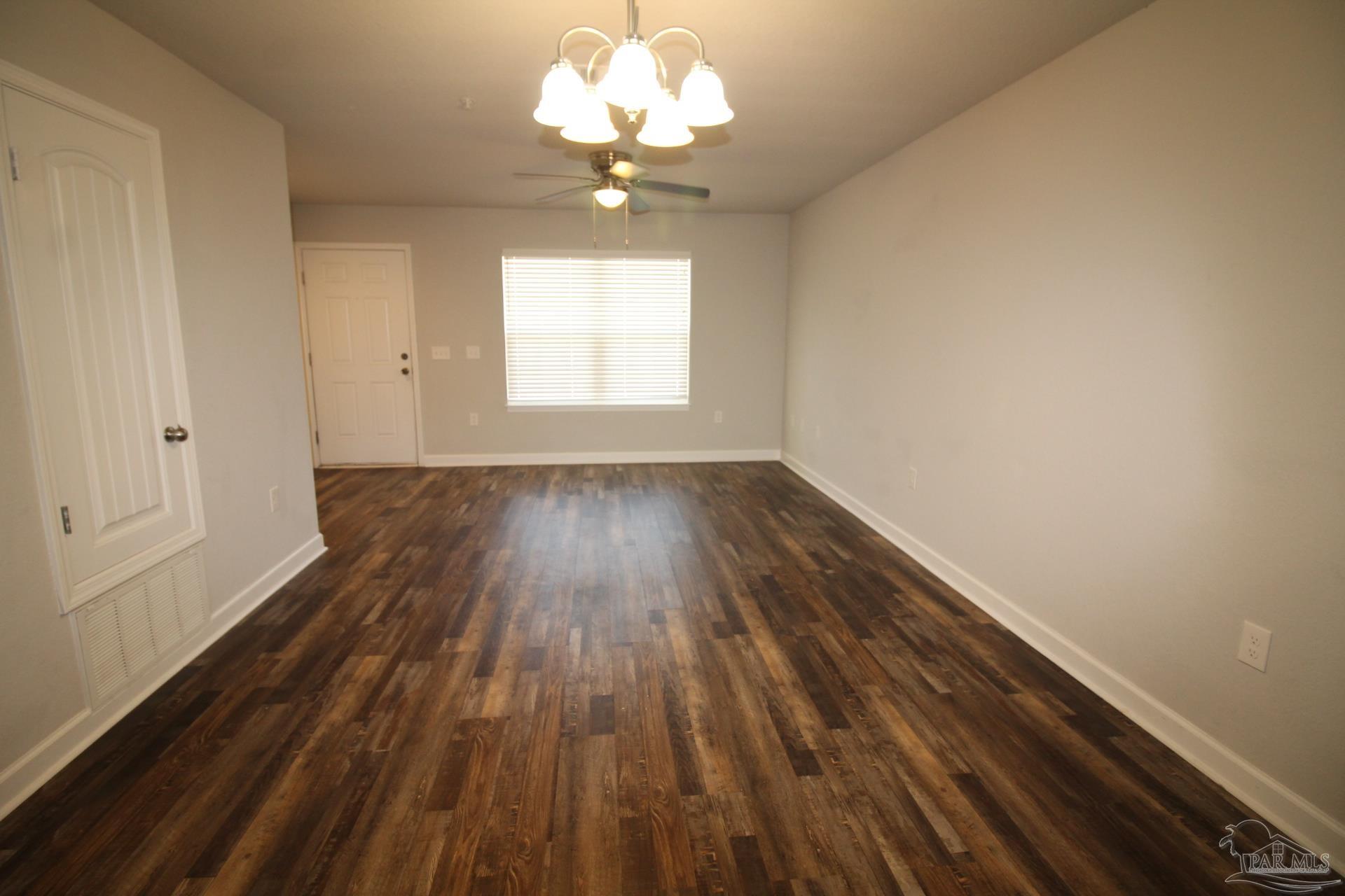 150 South Crow Road, Unit 403 Pensacola, FL 32506 - Photo 3 of 16 wooden floor in an empty room with a window