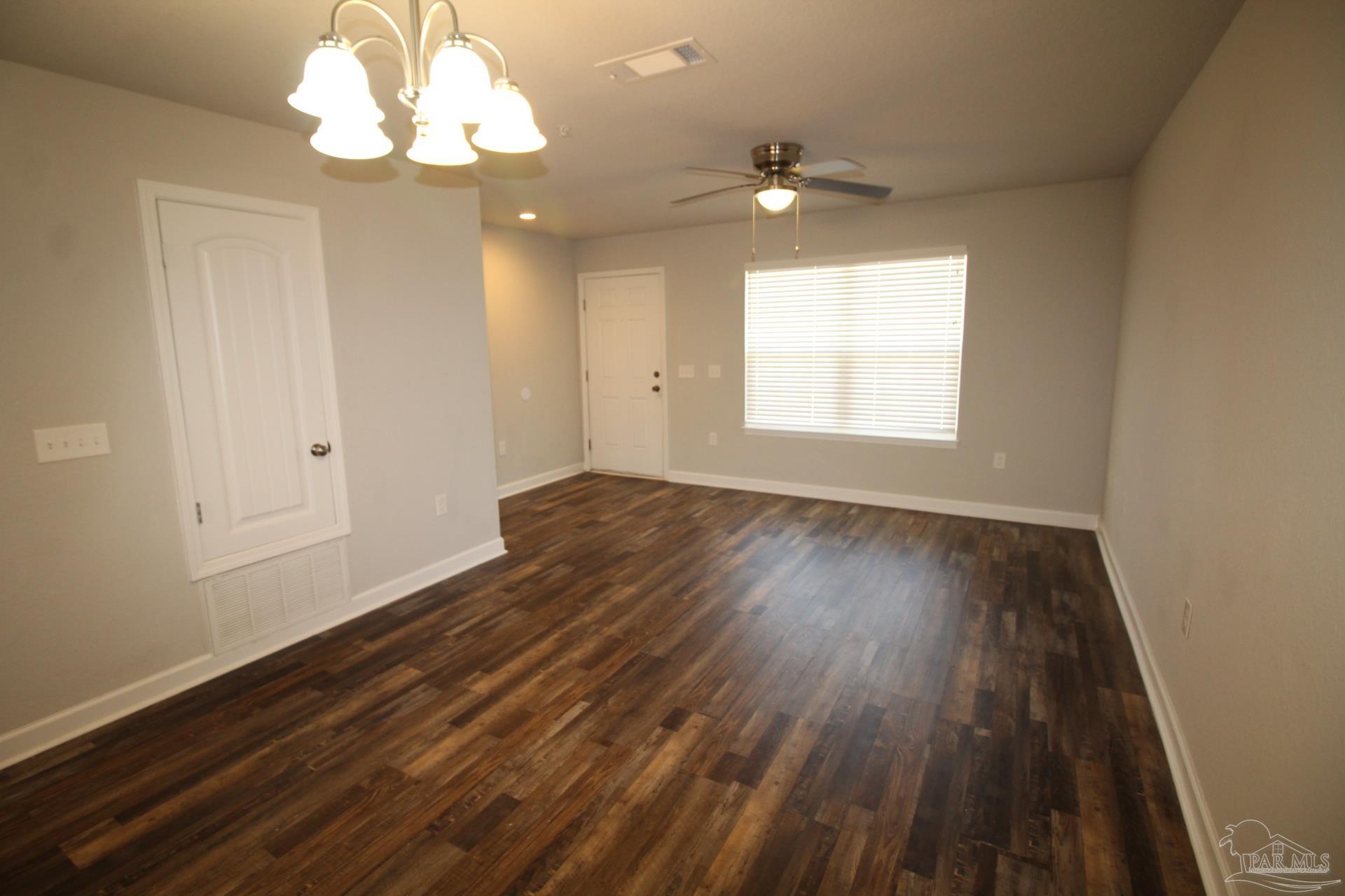 150 South Crow Road, Unit 403 Pensacola, FL 32506 - Photo 5 of 16 wooden floor in an empty room with a window