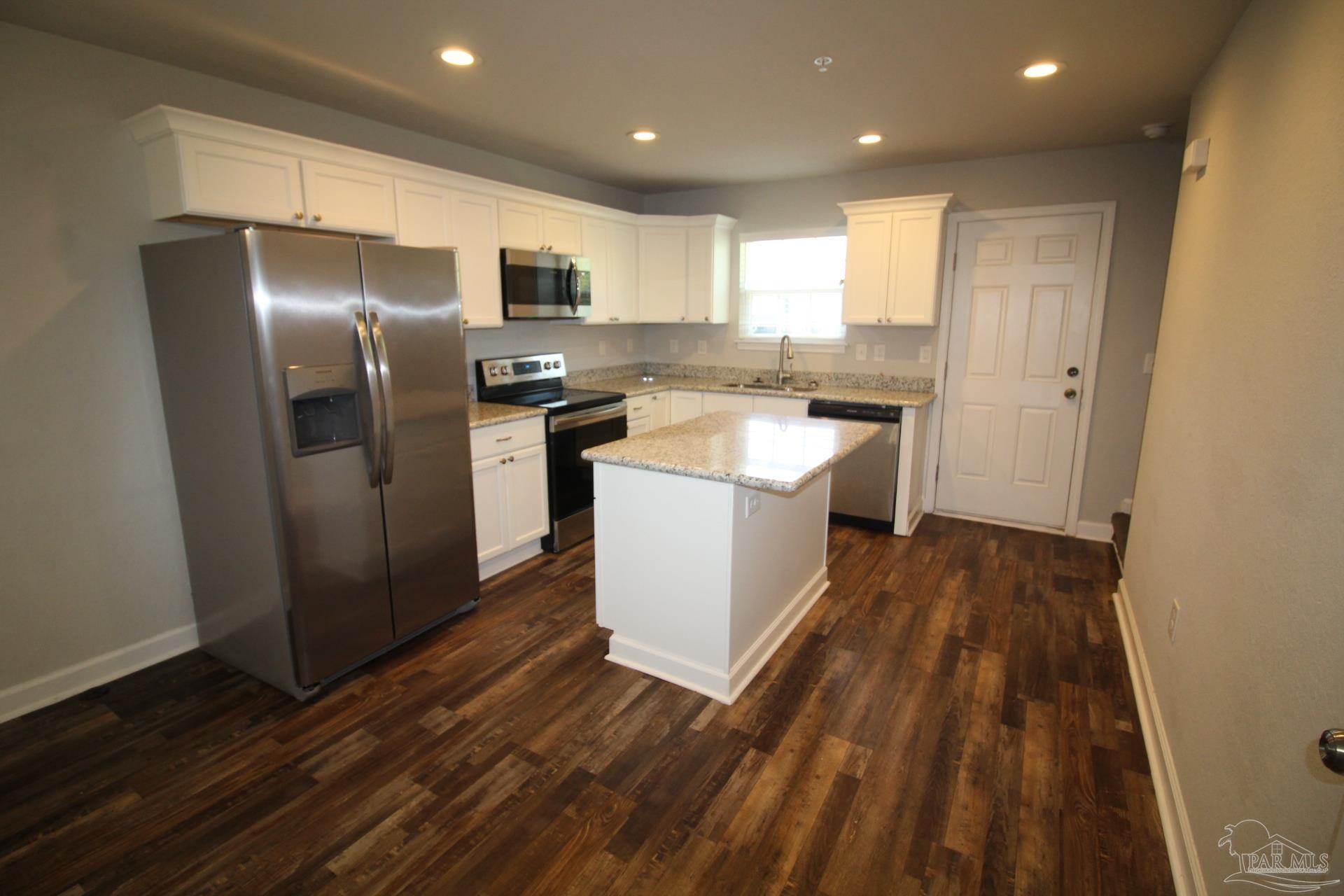 150 South Crow Road, Unit 403 Pensacola, FL 32506 - Photo 7 of 16 a kitchen with a refrigerator sink and wooden floor