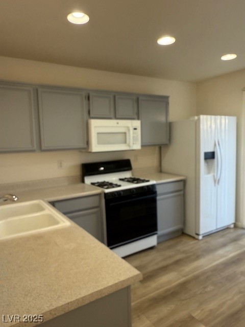 5474 Jacobs Field Street Las Vegas, NV 89148 - Photo 12 of 13 Kitchen featuring gray cabinetry, stove, recessed lighting, light wood finished floors, and fridge