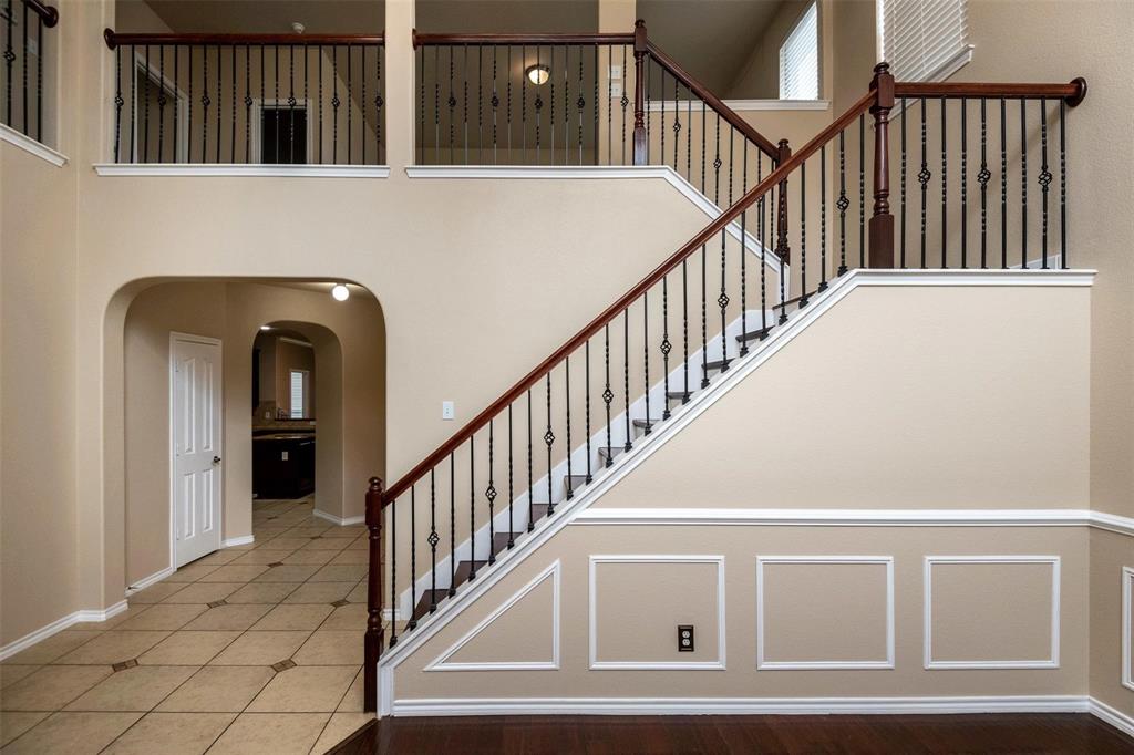 7607 Yearling Way Arlington, TX 76002 - Photo 21 of 25 a view of staircase with railing and a chandelier