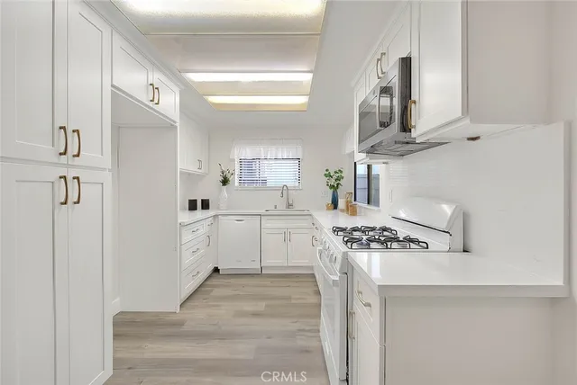 a room with white cabinets and white appliances