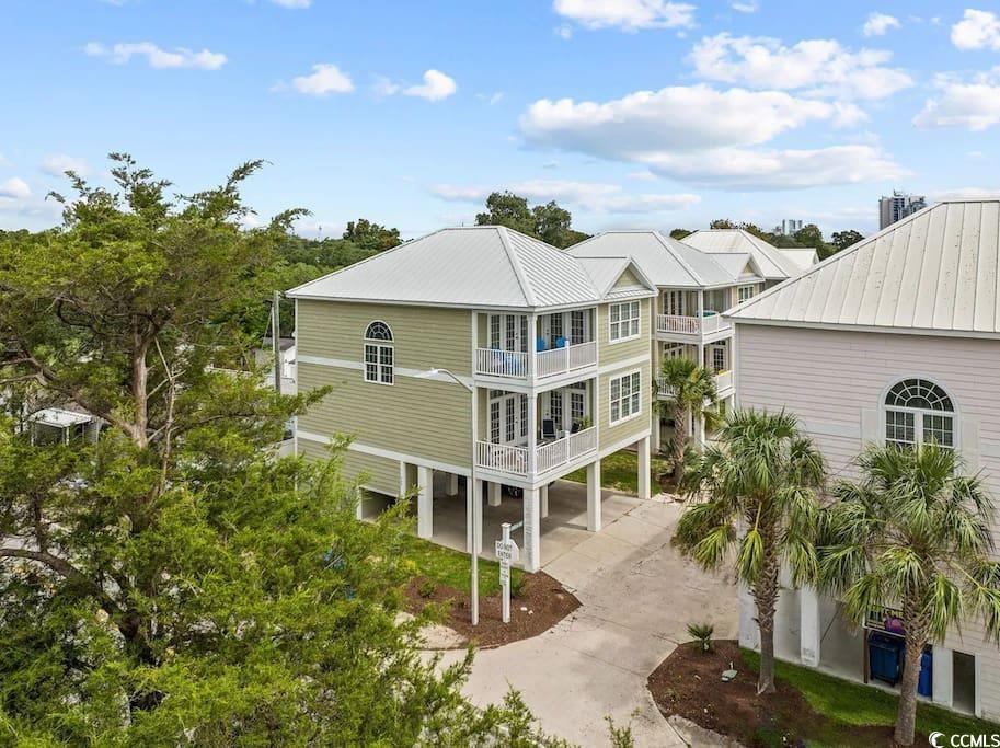 544 Caribbean Way Myrtle Beach, SC 29577 - Photo 1 of 31 Back of house with a carport, a metal roof, concrete driveway, and a balcony