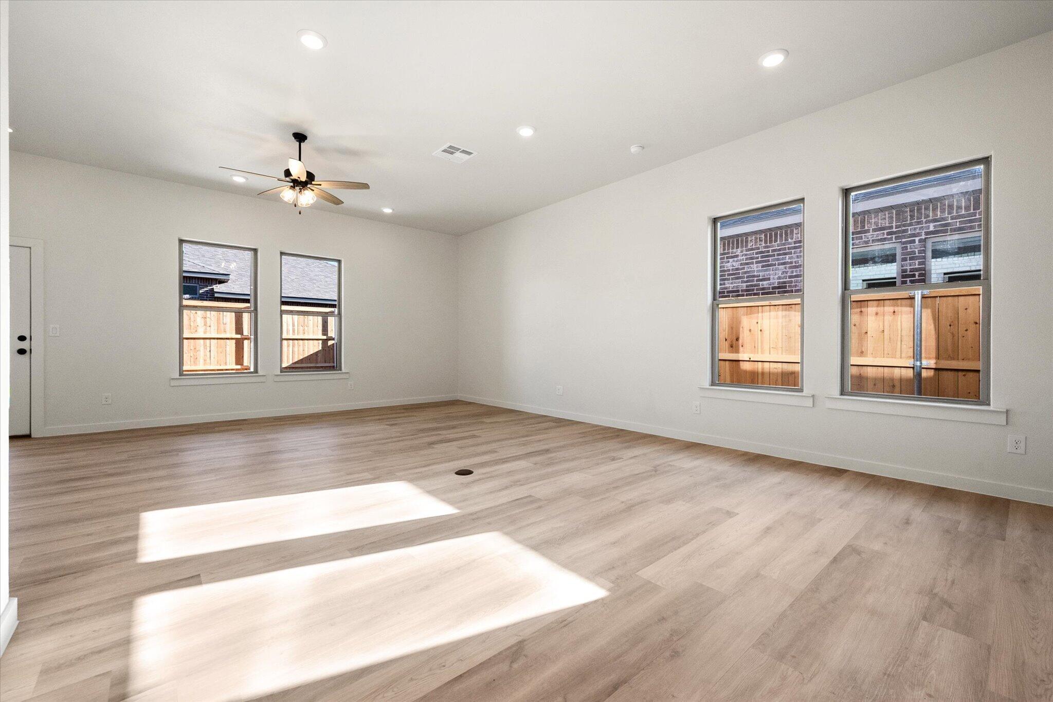 6925 53rd Street Lubbock, TX 79407 - Photo 11 of 22 a view of an empty room with a window and wooden floor
