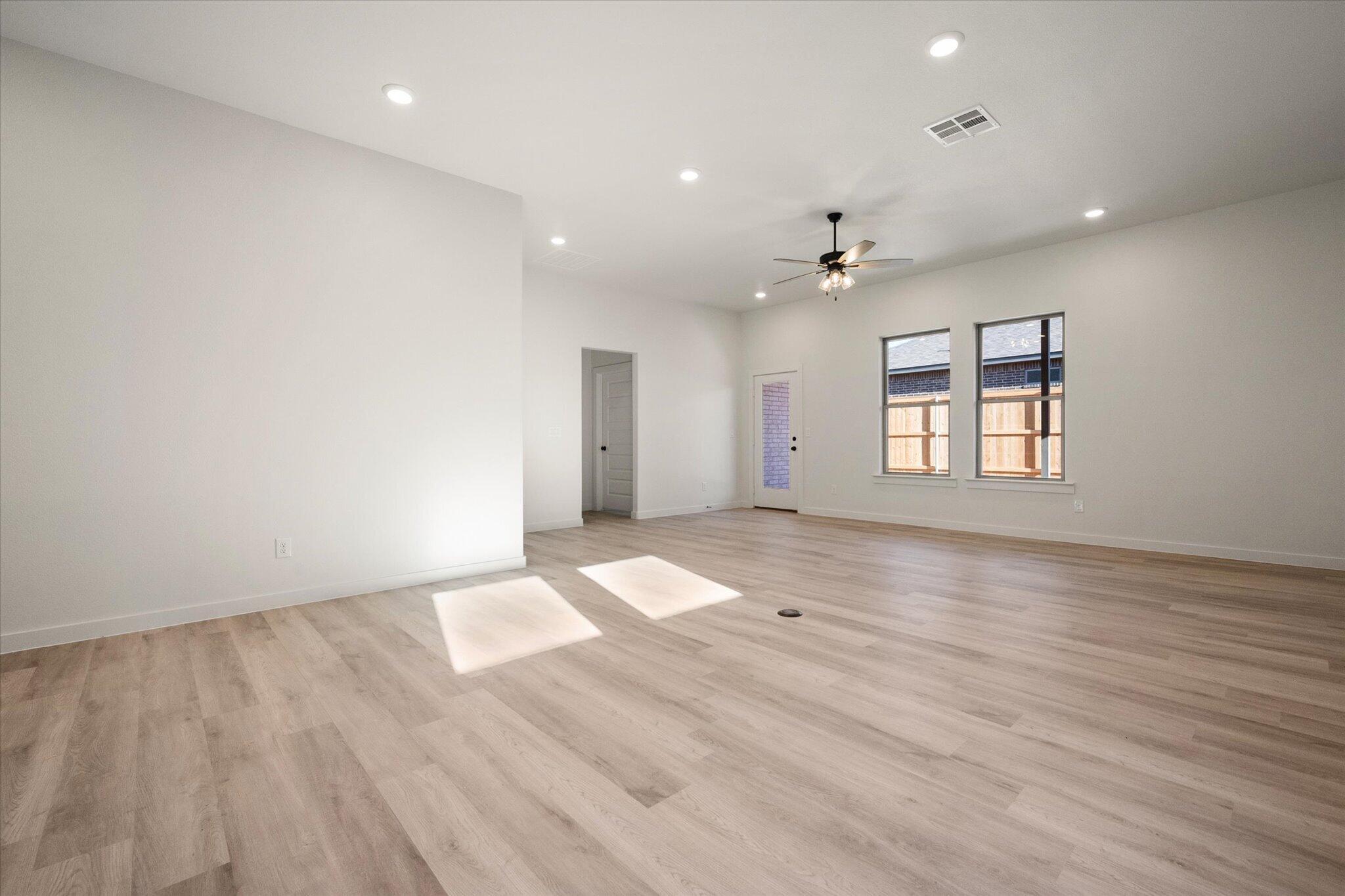 6925 53rd Street Lubbock, TX 79407 - Photo 12 of 22 an empty room with wooden floor and windows