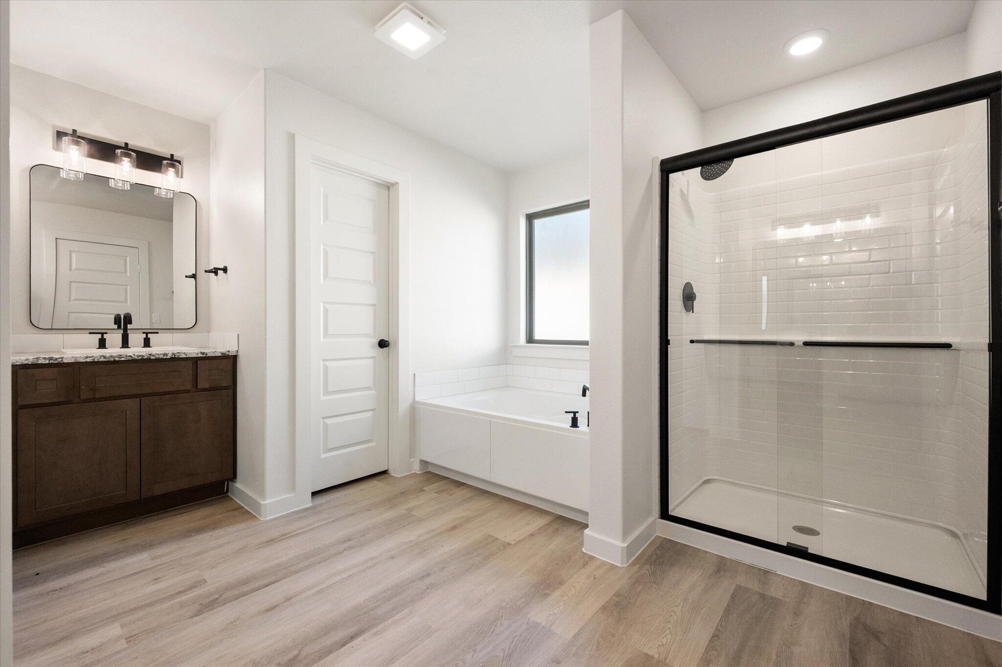 6925 53rd Street Lubbock, TX 79407 - Photo 14 of 22 a bathroom with a tub shower vanity and a sink