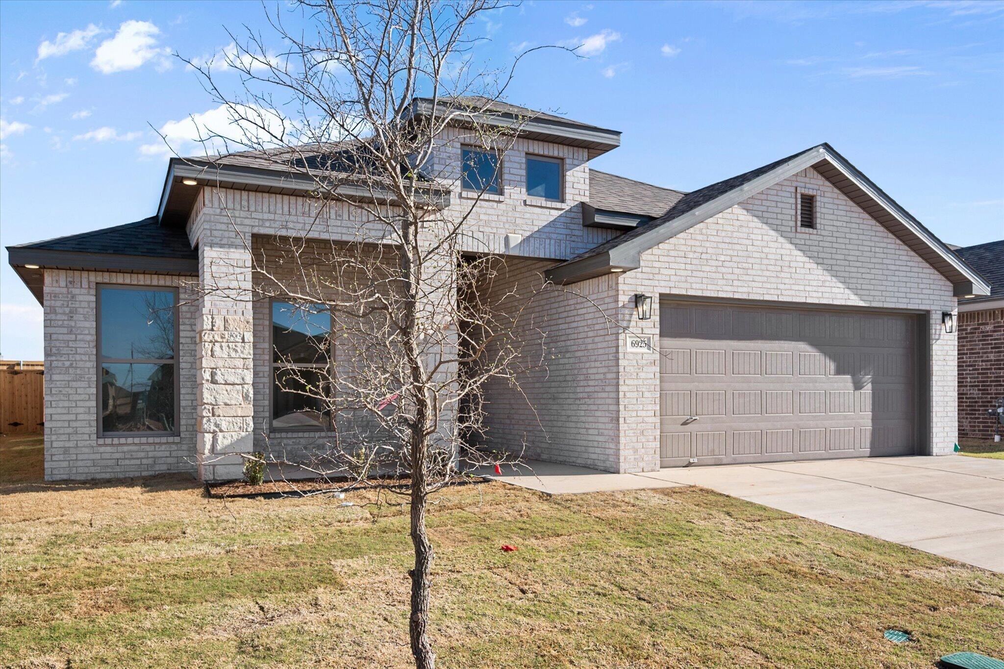 6925 53rd Street Lubbock, TX 79407 - Photo 2 of 22 a front view of a house with a yard