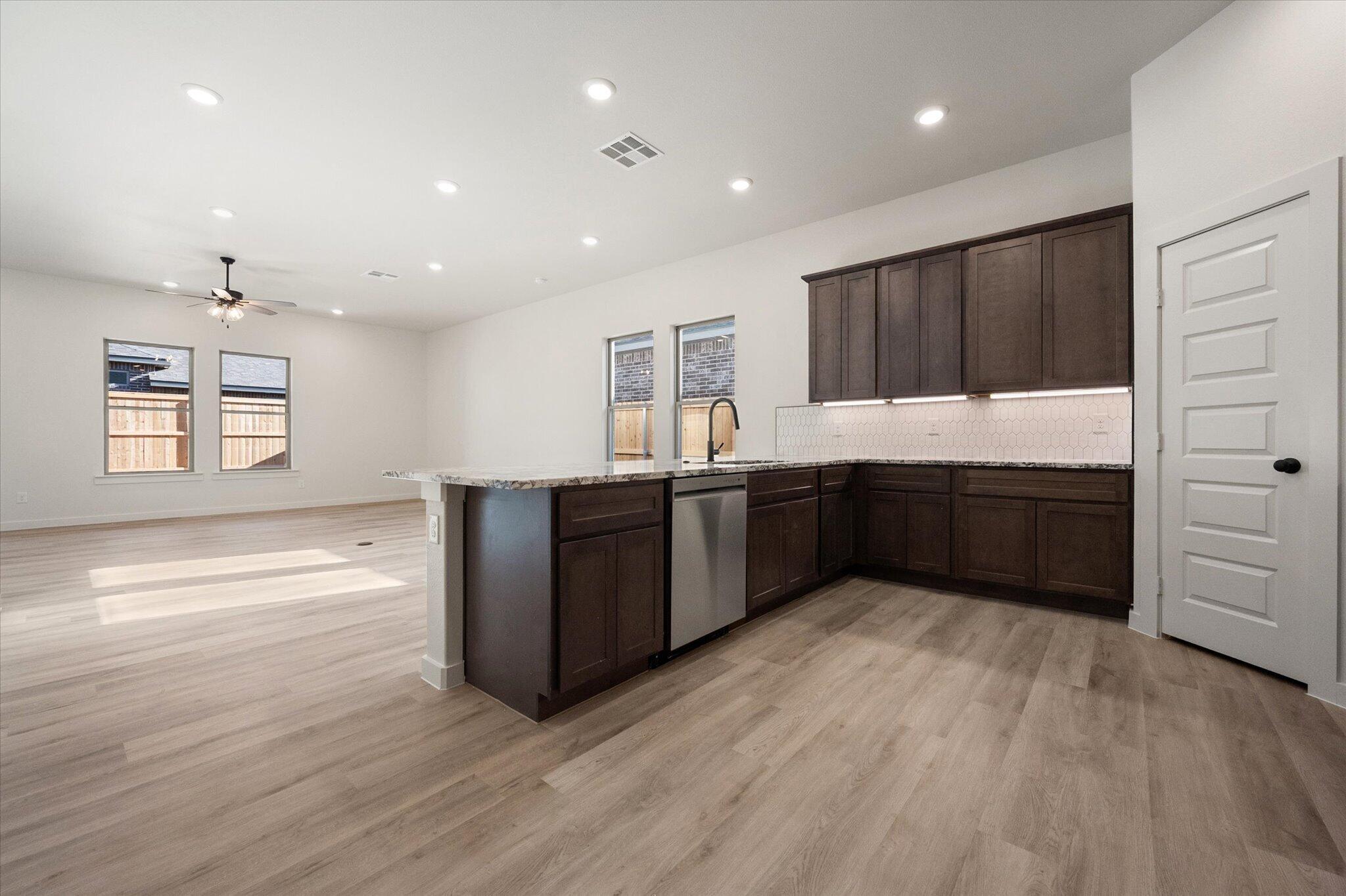 6925 53rd Street Lubbock, TX 79407 - Photo 6 of 22 a kitchen with stainless steel appliances granite countertop a stove a sink and a refrigerator